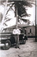 Black and white photo of Elisha Jarriel standing by his car, circa 1940s
